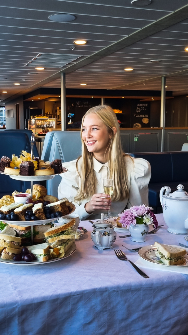 dame med bobleglass på afternoon tea på fjorden