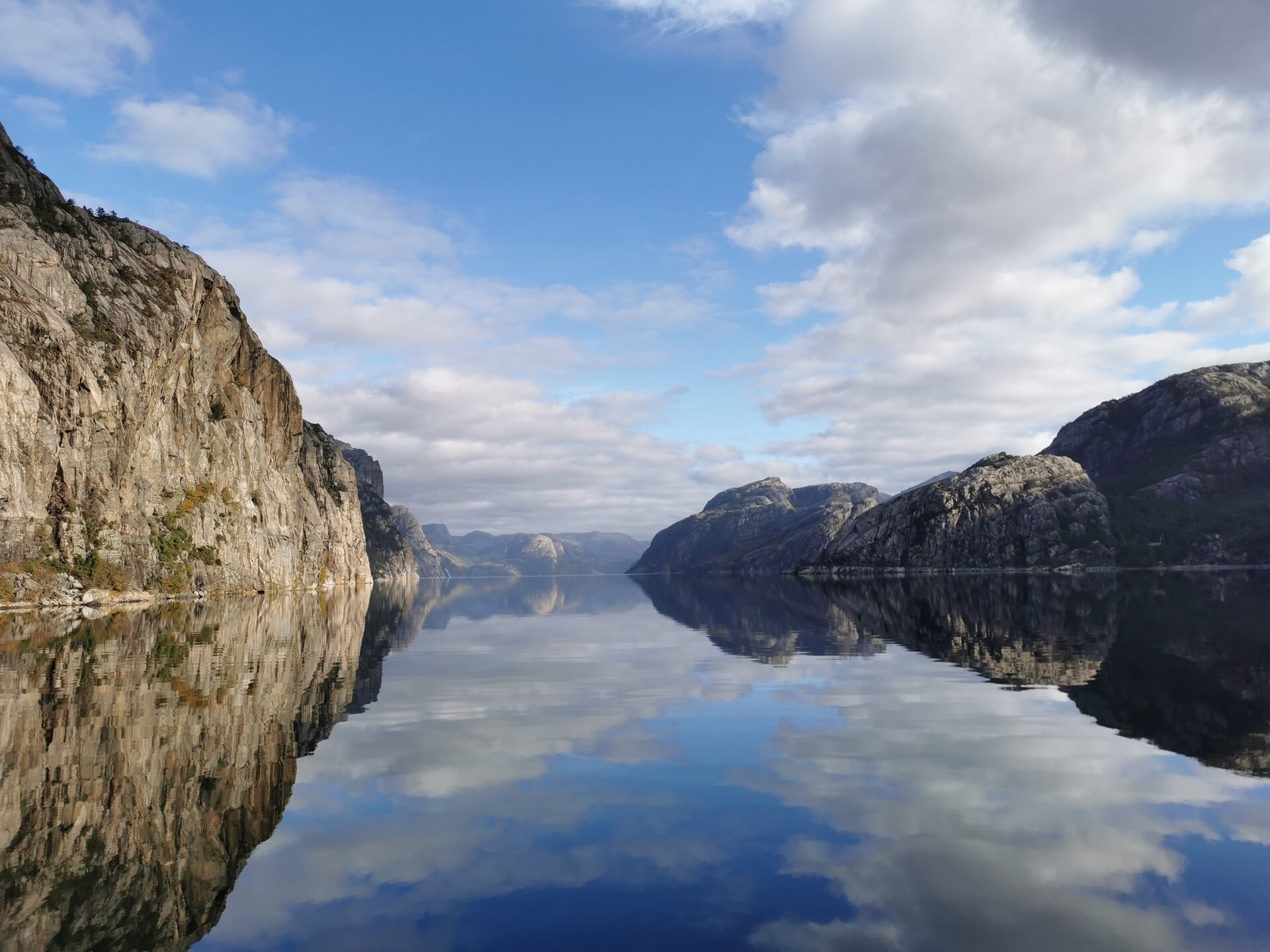 Stille dag på fjorden hvor fjellene speiler seg i den speilblanke Lysefjorden