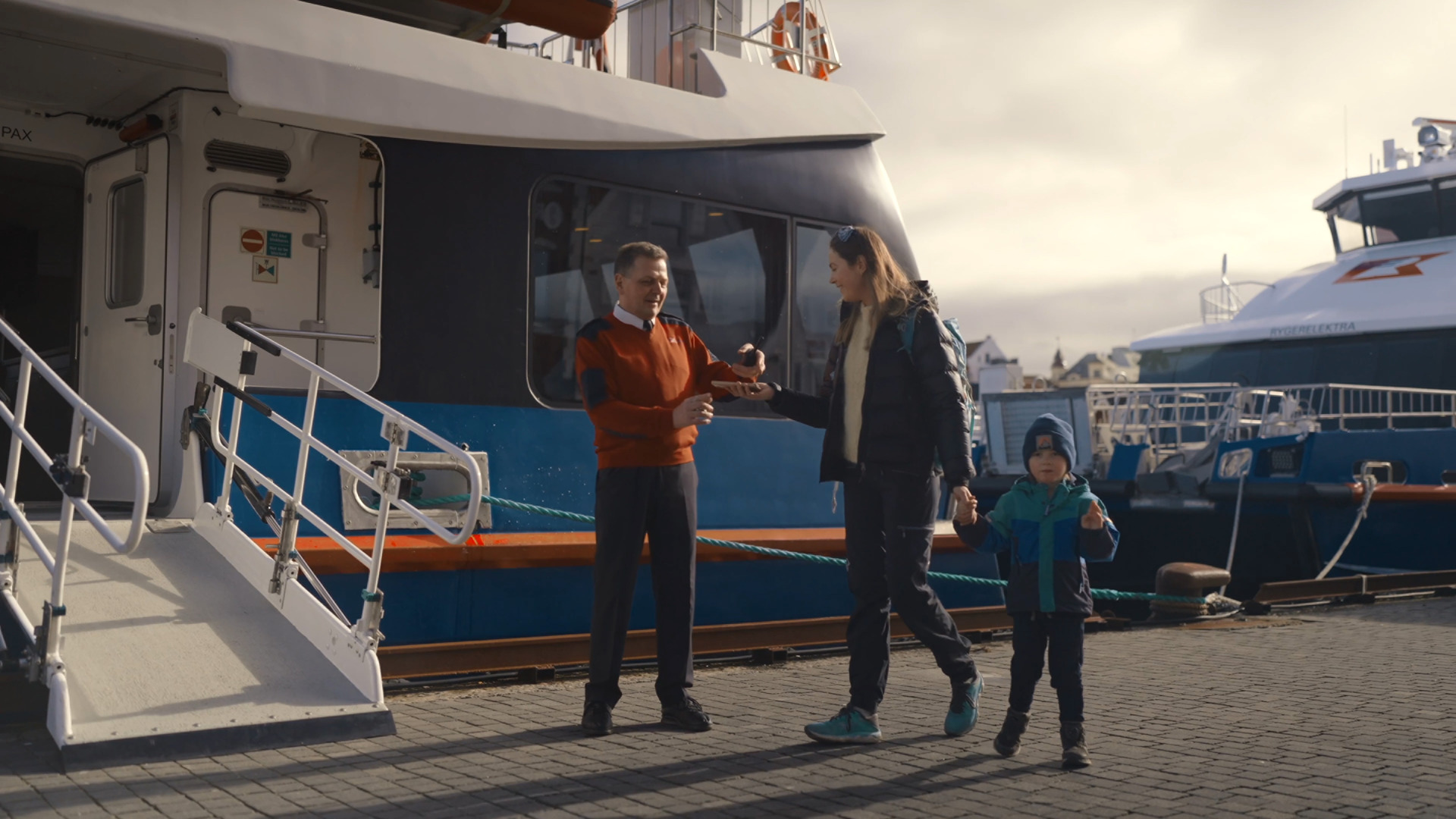 Hyggelig mannskap tar imot en mor og henne barn før avgang til Lysefjorden fra Stavanger