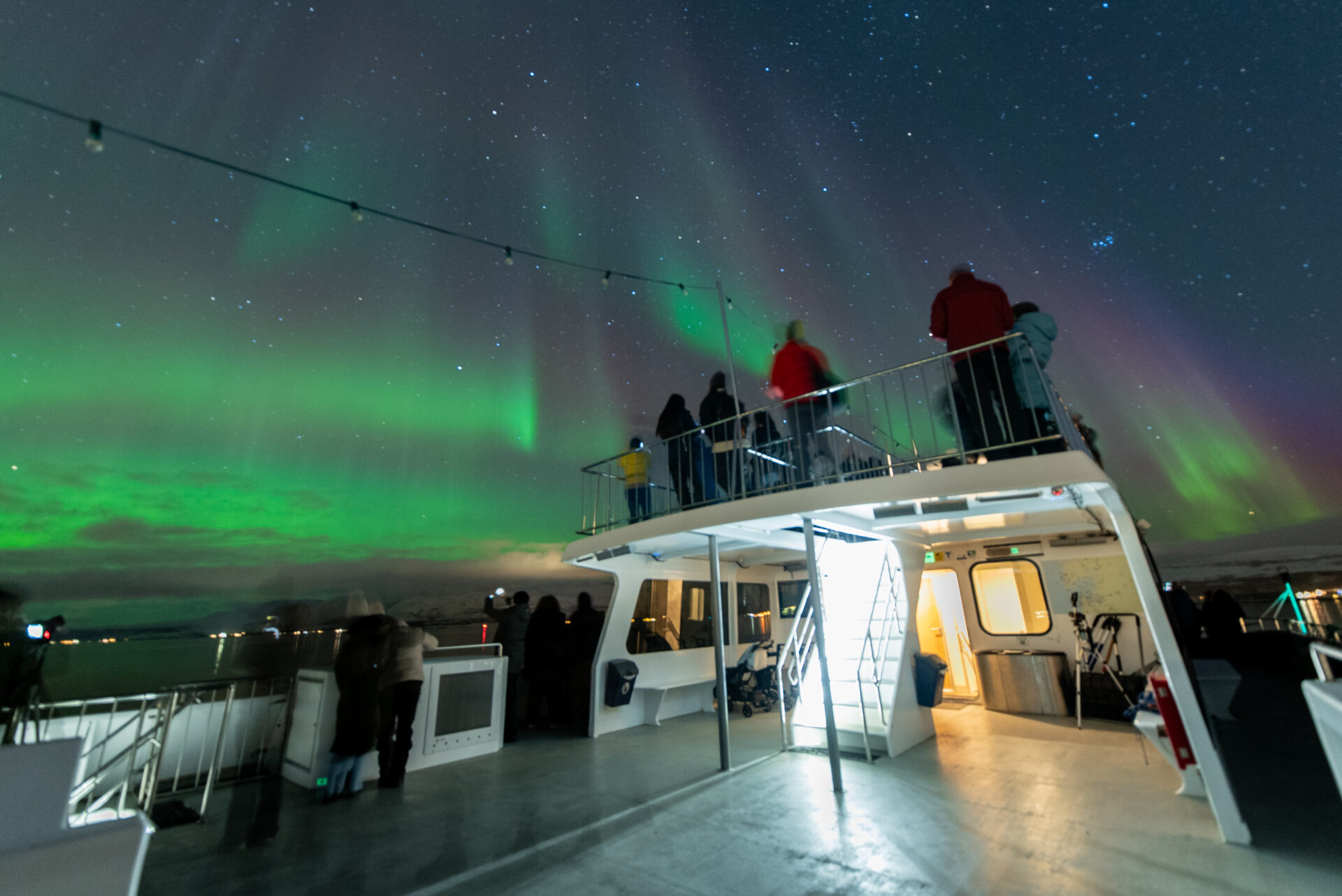 Personer på Rygerdronningen under Nordlys-himmelen