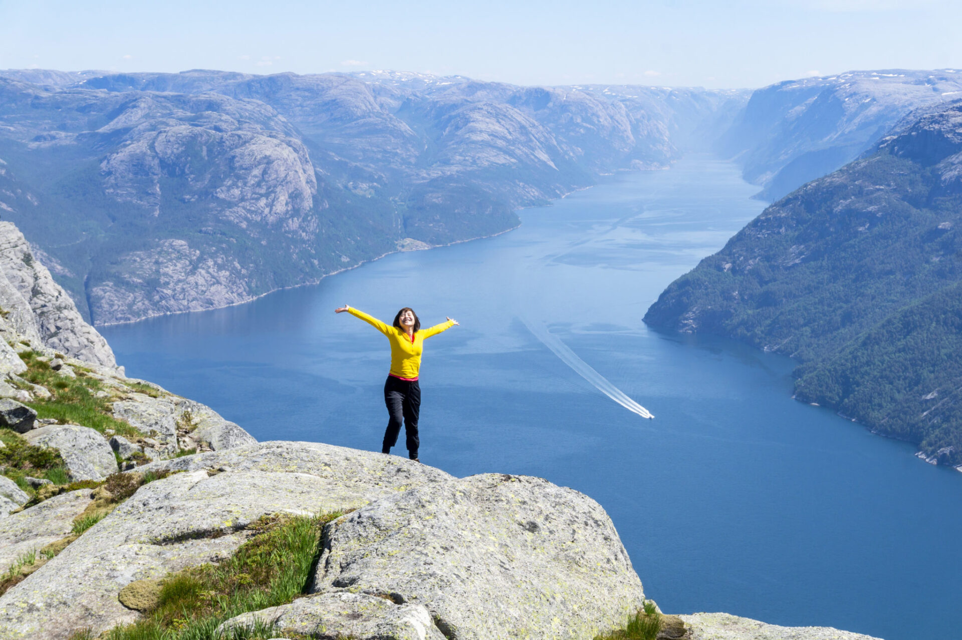 Happy tourist posing in front of the spectacular view over Lysefjord