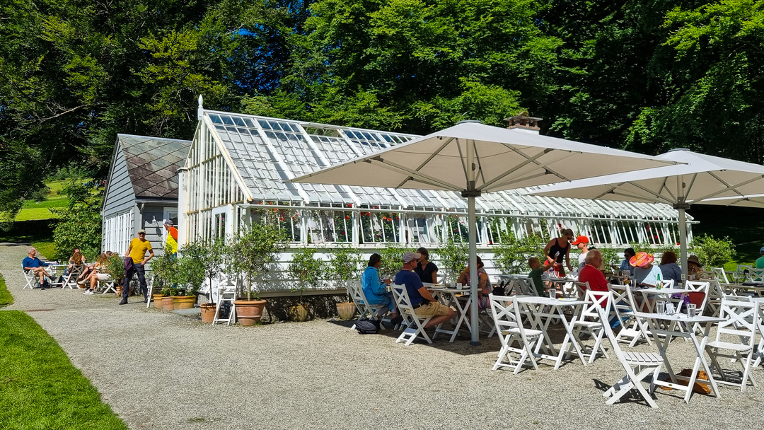 The garden restaurant at Baroniet Rosendal, where visitors can dine in a peaceful setting surrounded by blooming flowers and historic charm.