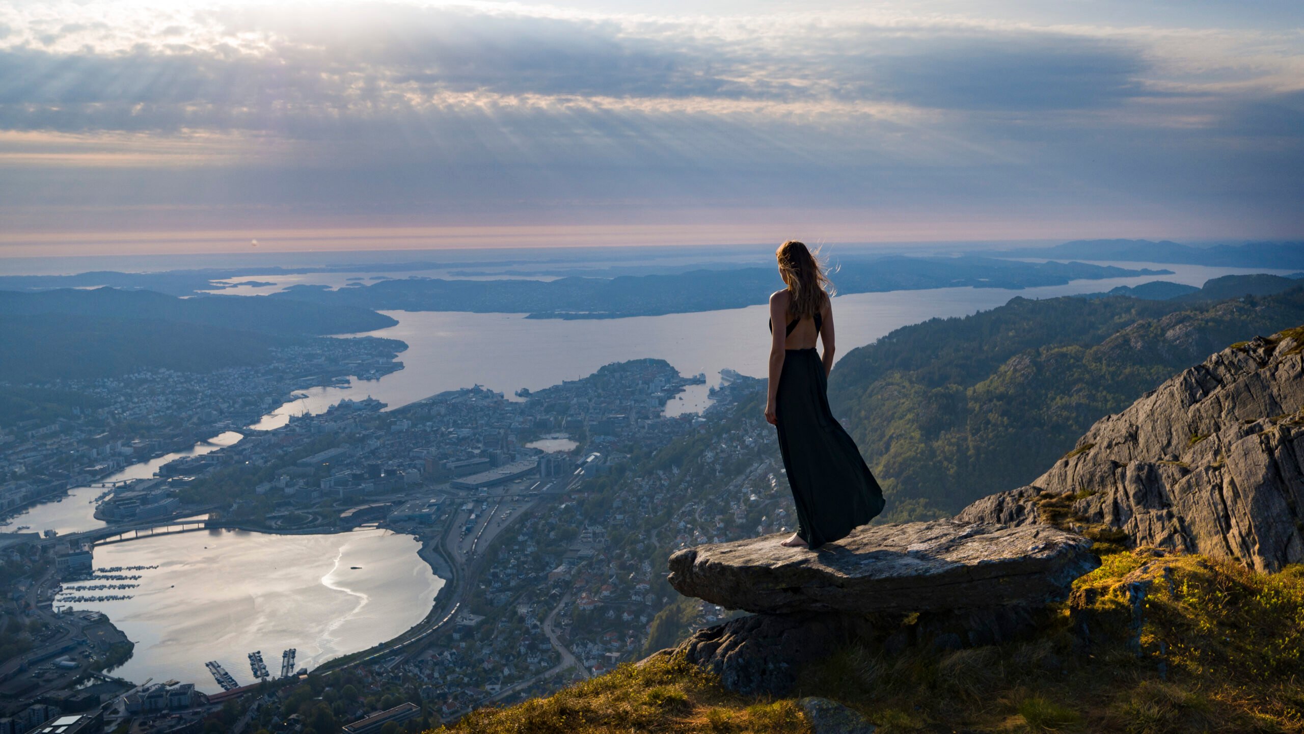 dame i kjole på byfjellene med utsikt over Bergen by