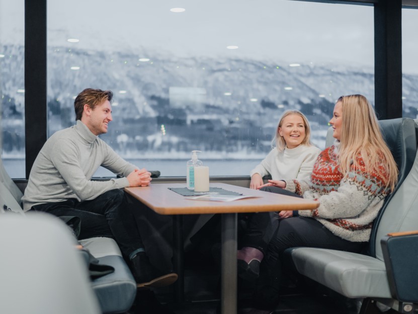 Smiling passengers aboard Rygerdronningen catamaran during an Arctic fjord cruise in Tromsø