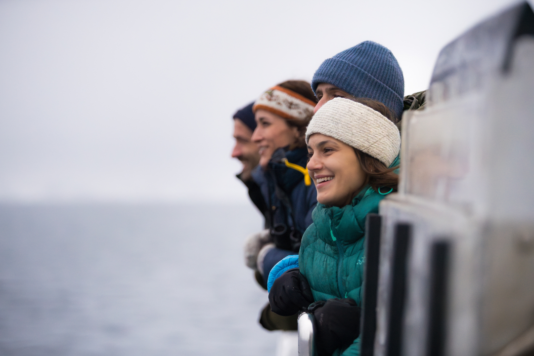 Passengers enjoying panoramic views of the Arctic fjords from the deck of a comfortable catamaran near Tromsø