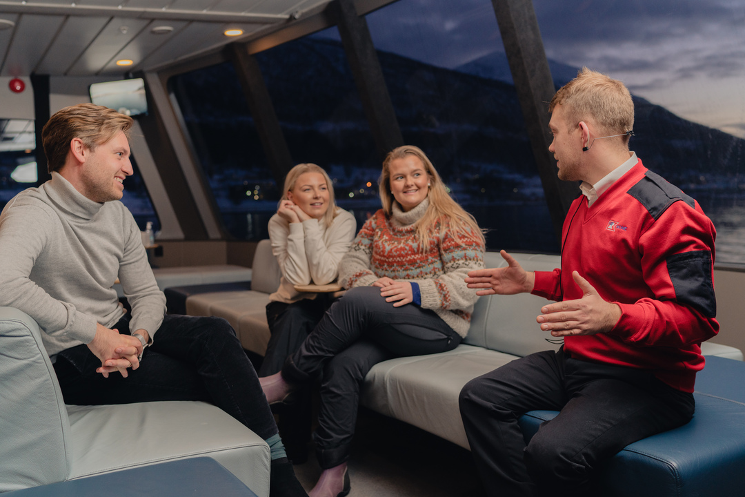 Cozy interior of the boat with passengers enjoying the guide talking to them.