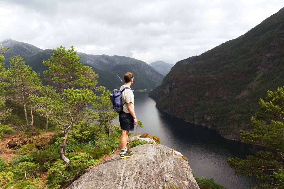 A guided hike to Slottet, known as Bergen’s mini Preikestolen, offering breathtaking fjord views and a peaceful, crowd-free experience. A hiker overlooking the Mo fjord with views to the small city Mo.