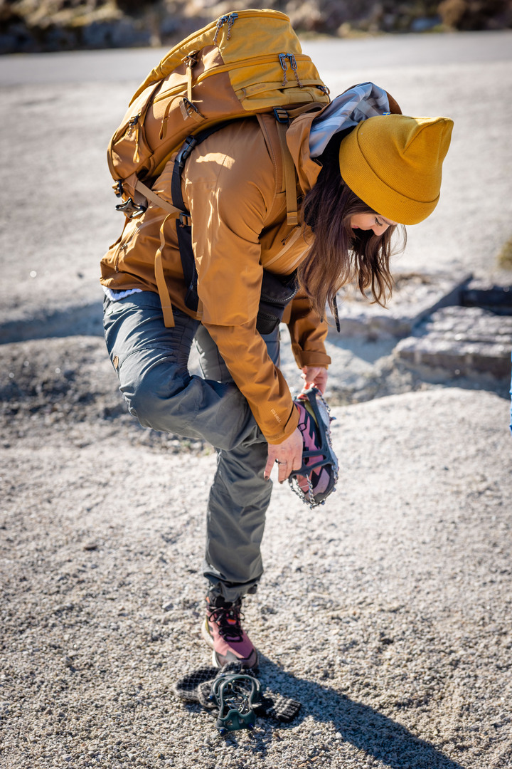 Guest putting on crampons(shoes spikes) before starting the hike to Preikestolen