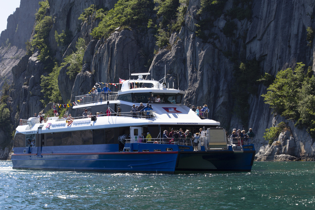 Passengers enjoying the spacious viewing decks of a modern sightseeing boat on a fjord cruise from Stavanger to Lysefjord and Preikestolen, surrounded by stunning Norwegian nature.