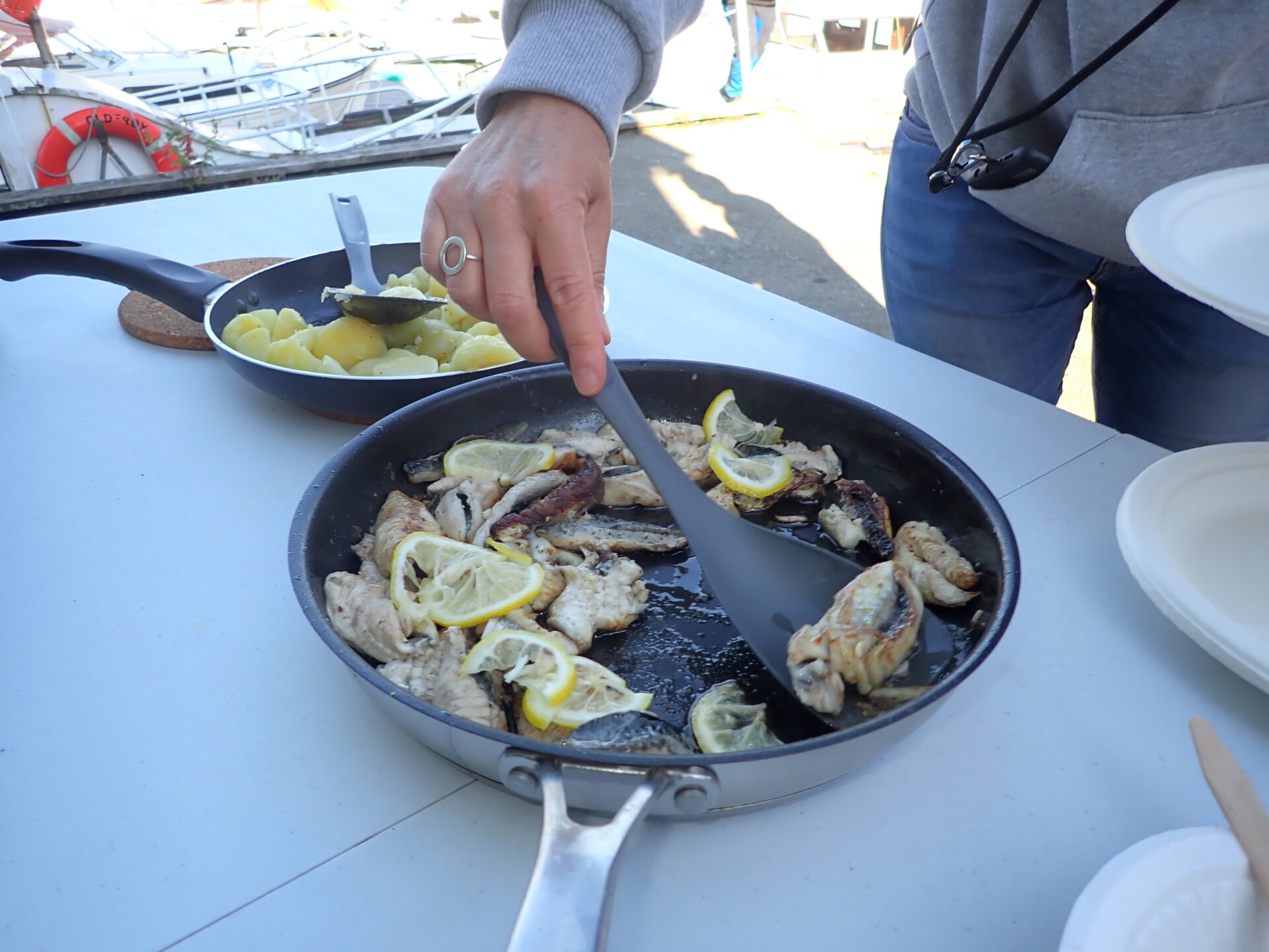 Cooking freshly caught fish with lemon and herbs on a boat