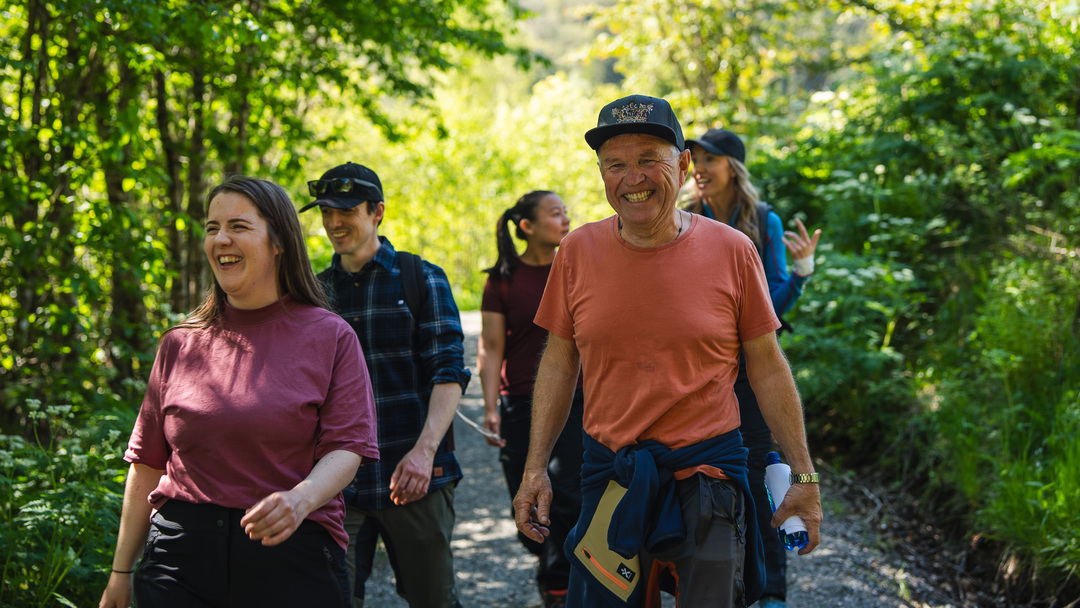 Smiling hikers at the forest trail path towards Kossdalssvingane